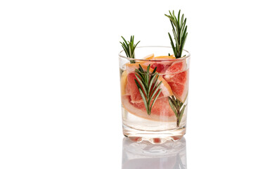 Glass of water with grapefruit and rosemary on a white background.