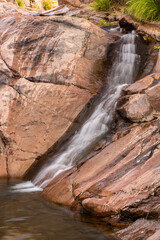 Obraz premium USA, Arizona, Superstition Wilderness. Water cascade down rock face.