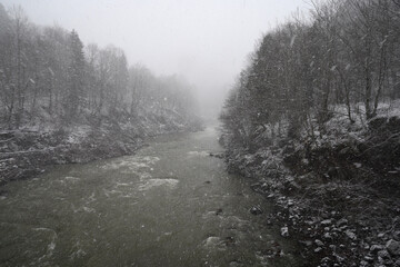 Fototapeta na wymiar Landscape with mountain river in severe blizzard