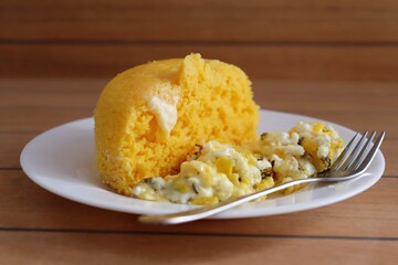 Brazilian couscous and scrambled eggs (Cuscuz com ovo) on wooden background. Typical Couscous of Northeast of Brazil.