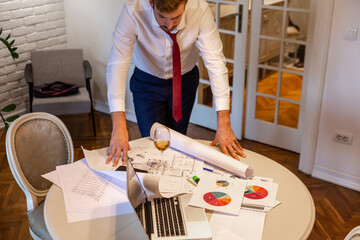 Fototapeta premium A young businessman is working remotely from home late at night. 