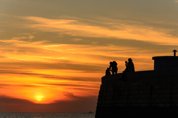 beautiful sunset while catching the silhouette of two photographers, male and female.