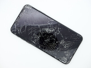 Modern space grey smartphone with a broken glass display and damaged curved body close-up isolated...