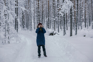 Fototapeta na wymiar Young girl walking the winter forest