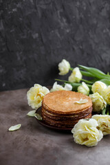 Rice pancakes on the table with a bouquet of tulips. Spring decoration of the dining table. Still life with flowers.