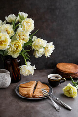 Rice pancakes on the table with a bouquet of tulips. Spring decoration of the dining table. Still life with flowers.