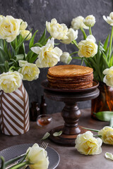 Obraz premium Rice pancakes on the table with a bouquet of tulips. Spring decoration of the dining table. Still life with flowers.