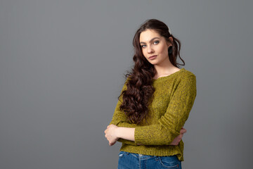 portrait of beautiful sensual woman with long curly hair against gray background