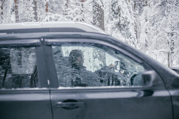 man follows the road in a navigator and drives a car through a winter forest