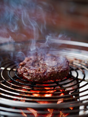 Close up of a fresh wagyo patty roating on a charcoal grill