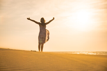 Freedom and happiness. Along young woman on sand enjoying sun, nature.