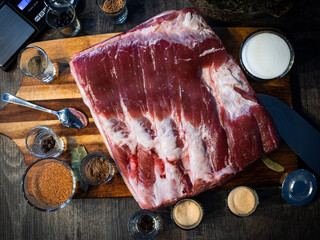 Close up of pork belly with spices, on a wooden board.