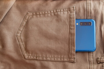 Modern 3d camera smart phone in  pocket. Top view of blue gadget, horizontal orientation