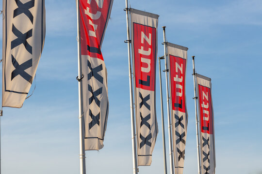 Dreieich, Germany - February 20, 2021. Flags on the grounds of the furniture house xxxlutz or mannmobilia with blue sky