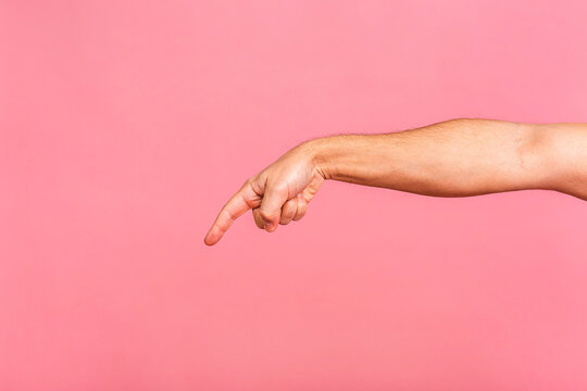 Caucasian male hand point finger. Hand gestures - man pointing at virtual object with index finger isolated on pink background.