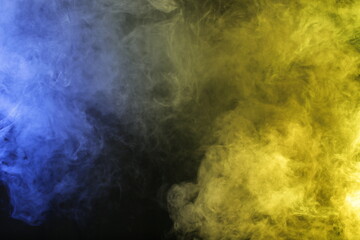 Smoke in blue yellow light on black background
