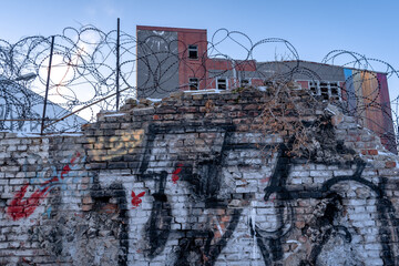 building with graffiti wall and barbed wire