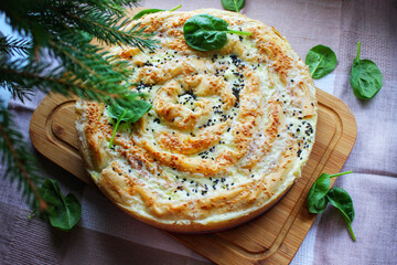 Homemade baked goods with a crispy crust meat pie on a wooden cutting board