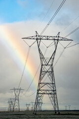 USA, California. Mojave Desert, Antelope Valley, rainbow and electric transmission lines.