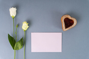 biglietto rosa due fiori piccoli e biscotto a forma di cuore