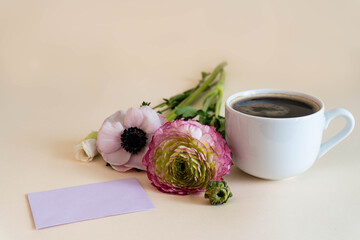 Biglietto fiori e tazza con caffè su sfondo arancione