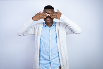 Young handsome african american man wearing casual clothes covering eyes with hands smiling cheerful and funny. Blind concept.