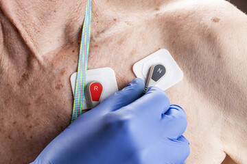 cardiology monitoring equipment ecg holter monitor. senior adult men with cardio monitor on his...