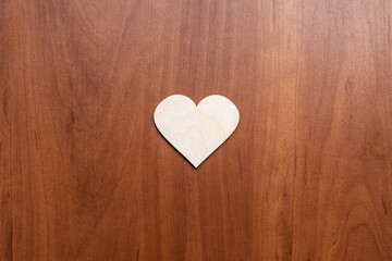 Fototapeta premium wooden heart symbol on wooden background. valentine greeting card concept. above view