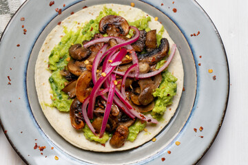 Mushroom and guacamole tacos on white background. Mexican food