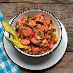 Wieners cocktail with avocado and ketchup on wooden background. Mexican food