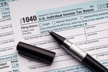 Tax Form 1040 and ballpoint pen. Filling in a tax return.