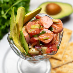 Wieners cocktail with avocado and ketchup on white background. Mexican food