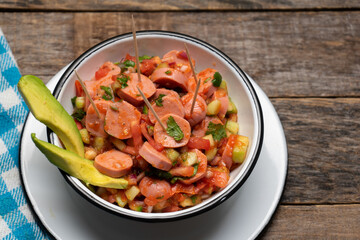 Wieners cocktail with avocado and ketchup on wooden background. Mexican food