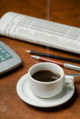 Office desk table with financial concept, calculator, cup of coffee and newspaper