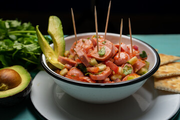 Wieners cocktail with avocado and ketchup on turquoise background. Mexican food