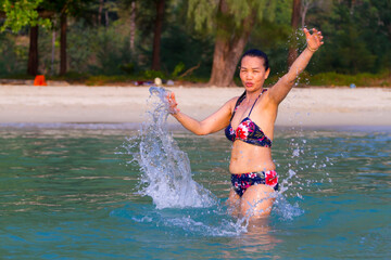 Woman is traveler play water at beach