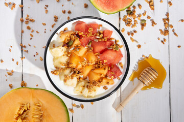 Fruit salad with honey and yogurt on white background. Healthy food