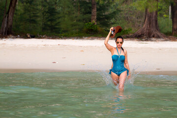 Woman beautiful in blue swimsuit walk play water