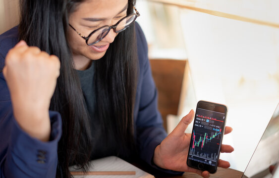 Happy woman smile while using laptop to trading stock exchange and success for the reach of the terget price
