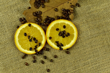 Plasterki pomarańczy, ziarna kawy i suchy liść.