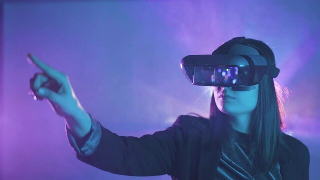 Anonymous woman in VR goggles in neon light