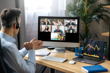 Online lesson or business webinar. Successful man sits at the work desk, on a computer screen are...