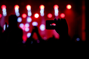 The smartphone in hands, shooting the concert stage.