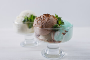 Chocolate, mint and vanilla ice-cream set in sundae bowl, refreshing creamy dessert for summertime. Food background