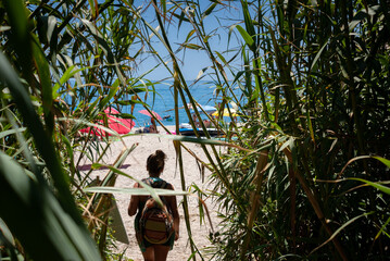 Piedra de Tarzan beach in Nerja, Maro. Silouette of a girl, bamboo canes and the sea in the background