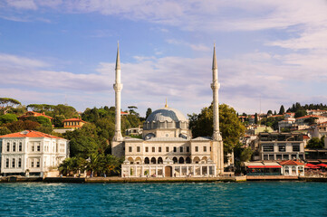 Fototapeta na wymiar View on the bank of Bosporus Strait with Beylerbeyi Hamid-i Evvel Mosque, baroque styled two minaret mosque in Beylerbeyi neighborhood of Uskudar municipality of Istanbul