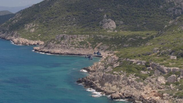 Private Helicopters Flying by Mountains and Rocks Cascading into the Ionian Sea