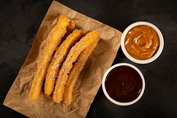 Traditional churros with sugar and chocolate sauce.