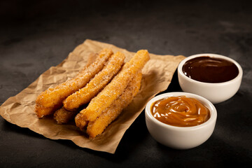 Traditional churros with sugar and chocolate sauce.