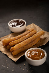 Traditional churros with sugar and chocolate sauce.